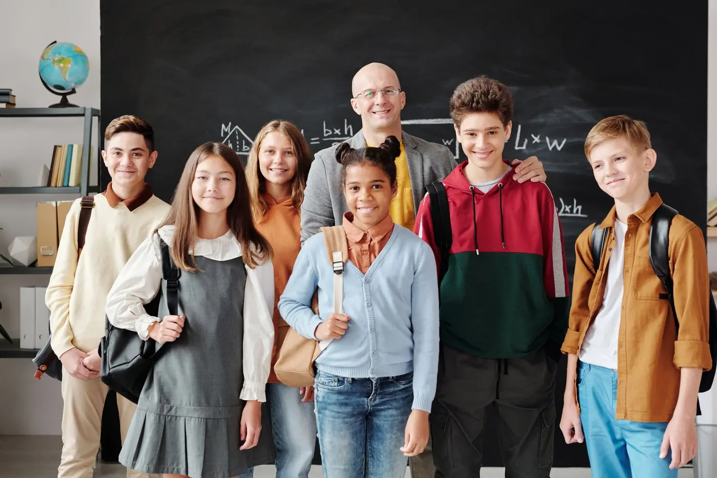 A diverse group of teenage students with their teacher in a classroom